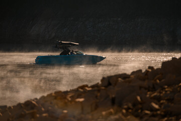 side view of modern motorboat on water surface with steam.