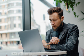 Fototapeta premium Young Caucasian business man zoom call on laptop in cafe. Businessman, freelance
