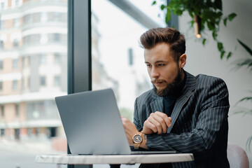 Fototapeta premium Young Caucasian business man zoom call on laptop in cafe. Businessman, freelance