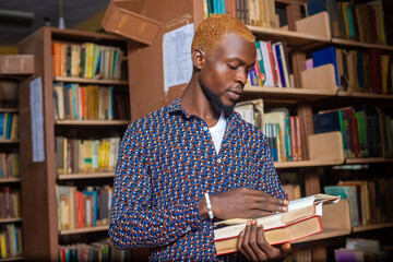 Young man reading book in library