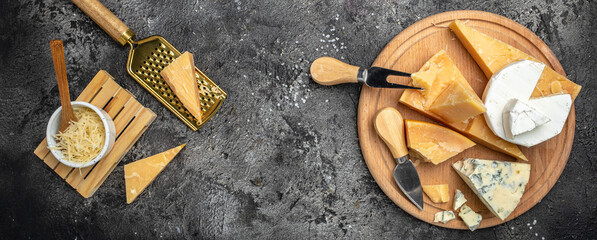 Parmesan. Cheeses set dor blu chedar camamber brie. Different types of cheese with knife on a dark background. Long banner format. top view