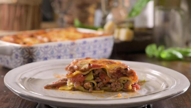 asagna with pesto. Italian lunch, homemade green lasagna with spinach in the dough, ragu - meat sauce, bechamel and parmesan cheese. Village dining atmosphere in Italy. Hot steam over food. footage