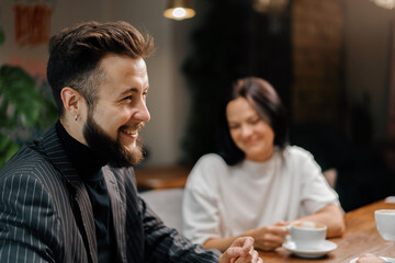 Cheerful company of friends socializing on weekend spending time together having lunch in cafeteria. Public place meeting. Friendship.