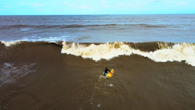vasi beach rajodi daone s hot of beach camera tilt up on rockes moving cloudes india maharahstra  surfing under blue sky brown sea fall in waves.