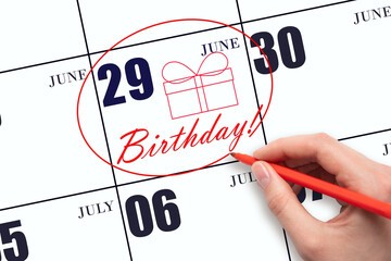 The hand circles the date on the calendar 29 June, draws a gift box and writes the text Birthday....
