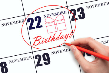 The hand circles the date on the calendar 22 November, draws a gift box and writes the text Birthday. Holiday.