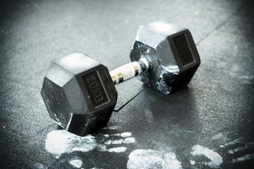 Single dumbbell weight lying on a gym floor