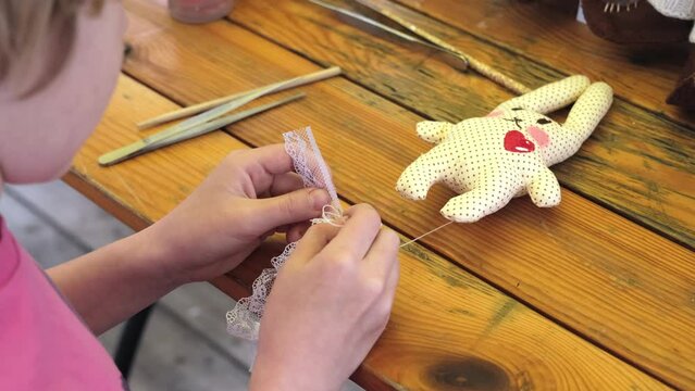 The child made a soft toy - a hare. The girl straightens her skirt on a toy. Easter Bunny. Handmade. Handmade soft toy
