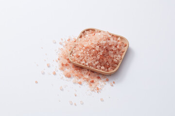 Front view of himalaya salt decorated in wooden bowl white background 