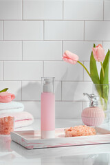 Front view of cosmetic jar decorated with himalaya salt towel and flower in ceramic tiles spa background 