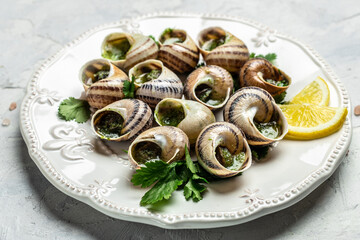 Escargots de Bourgogne Snails with herbs, butter, garlic, glass of white wine on a light background, gourmet food. Restaurant menu, Traditional French cuisine