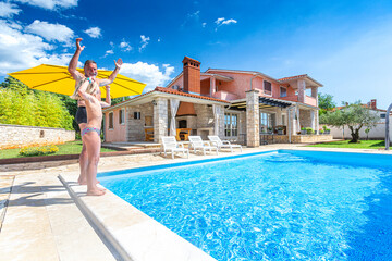 Croatia, Istria, Pula, blonde girl and grandpa having fun at the pool