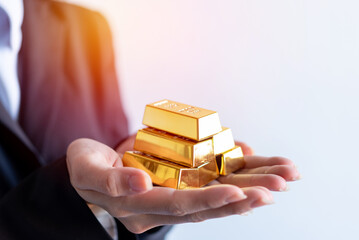 business female hand offering gold bar stack