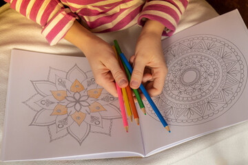 Woman coloring antistress page. Female hand painting mandala. Female painting mandalas to combat...