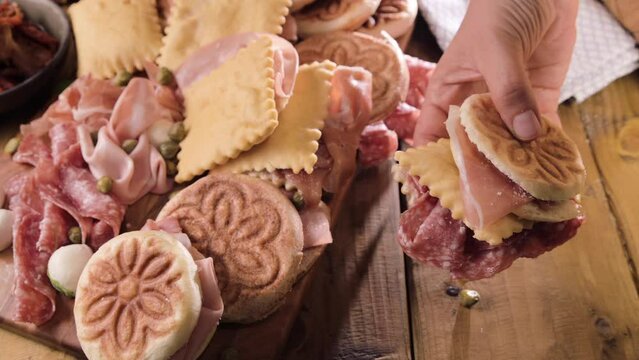 Crescentina. Food of Emilia Romagna region, deep fried bread gnocco fritto or crescentina. Starter or aperitif in Italy. Creshantina with prosciutto crudo, mortadella, Milanese salami, capers, cheese 