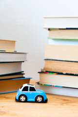 Blue toy  against the background of high and overhanging stacks of books. close up. copy space