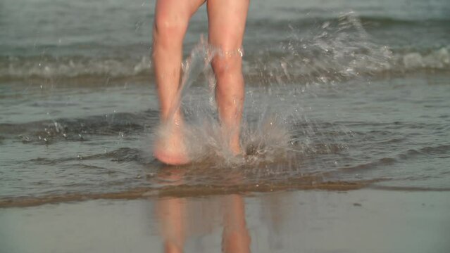 Kid feet splashing water, fun at the seaside