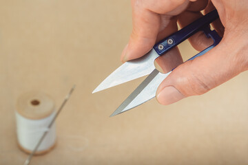 Tailor's snipper for trimming threads in hand. Close-up