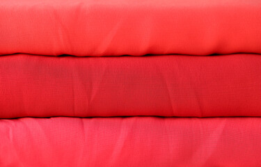 Red rolls of knitted fabric texture background