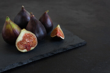 Fresh figs on the black stone board with copyspace