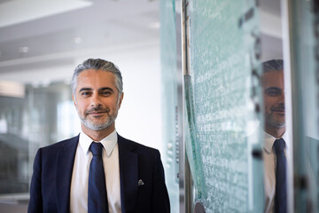 Portrait of Middle Eastern businessman with reflection in a modern corporate office