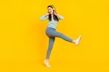 Fototapeta na wymiar Full body photo of good mood cheerful lady dancing have fun listen music in headset isolated on yellow color background