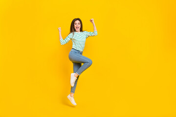 Fototapeta na wymiar Full length photo of good mood laughing screaming girl raise fists in victory win money isolated on yellow color background