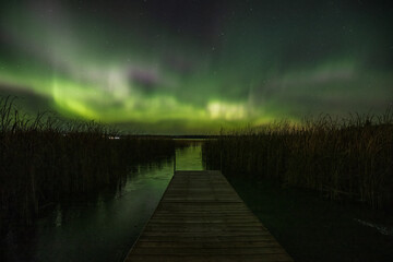 Watching an amazing show of the northern lights from a dock on a frozen lake in Northwest Ontario,...