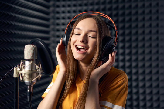 Girl in recording studio with mic over acoustic absorber panel background