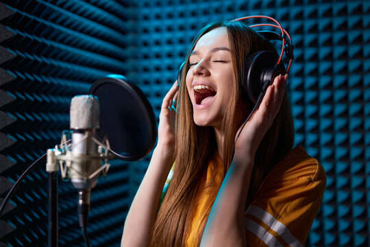 Girl in recording studio with mic over acoustic absorber panel background