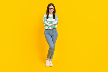Fototapeta premium Full body image of young stunning gorgeous business lady with folded arms isolated on yellow color background