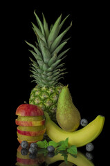 Red apple with pear ,banana,pineapple,black background