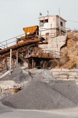 Fototapeta na wymiar Quarry machines and piles of gravel over blue sky. Stone crushing and screening plant