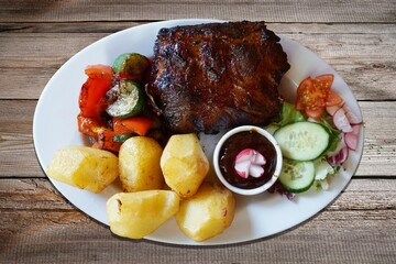 Barbecued spareribs with tomatoes and salad