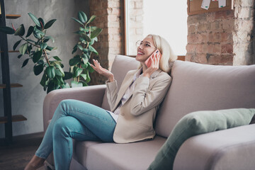 Obraz premium Profile photo of successful elegant lady sitting couch speak communicate telephone modern business center indoors