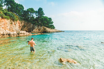 man swimming with snorkeling mask at blue azure sea water