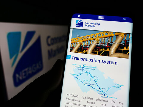 Stuttgart, Germany - 06-18-2022: Person holding cellphone with webpage of Czech gas transmission company NET4GAS sro on screen in front of logo. Focus on center of phone display.