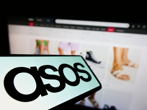 Stuttgart, Germany - 06-18-2022: Cellphone with logo of British fashion retail company ASOS plc on screen in front of business website. Focus on center-left of phone display.