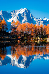 Beautiful reflection of Monte Rosa (Italian Alps) over Lake Arpy in autumn foliage Italy