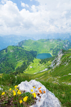 Panoramic view of lake, green alpine meadows and mountains