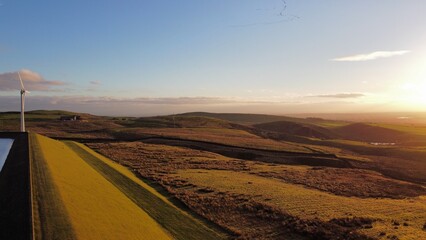 Aerial view of farmland and countryside with wind turbines in the distance. Taken in Bury Lancashire. 