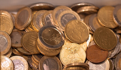 Heap of different euro coins. A lot of one euro, two euro and fifty cent coins in a box. European currency. 