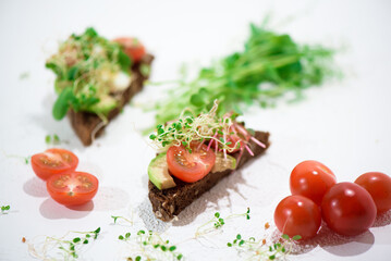 Fototapeta na wymiar Toasts with microgreens. Hand holds a healthy toast. Healthy food concept. Super food.
