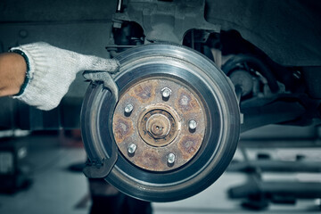 Deep grooves in old rusty disc brake rotors of the vehicle.