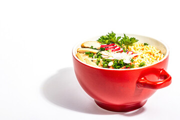 Asian noodles with chicken, vegetables, and herbs are isolated on a white background