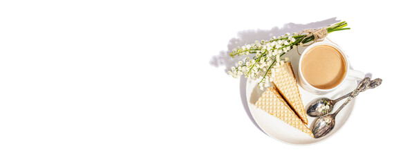 Cup of coffee and waffle cake isolated on a white background. Sweet dessert with lily valley bouquet