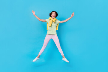 Fototapeta na wymiar Full length photo of hooray millennial brunette lady jump wear t-shirt pants footwear isolated on blue background