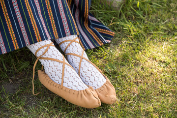 Leather bast shoes of a Latvian woman in traditional clothing. Preparing Ligo festival. Riga. Latvia