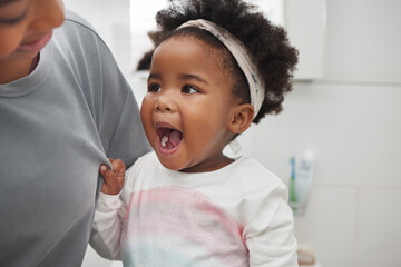 Look mom, its all clean. Shot of an adorable little girl opening her mouth to show her teeth to her...