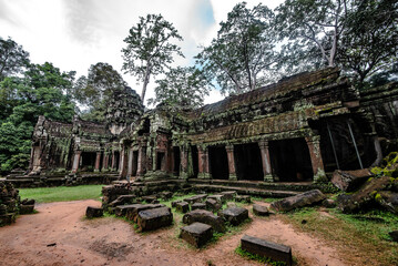 An ancient sandstone building that forms a walkway around the Ta Prohm temple at Angkor Wat. Siem...